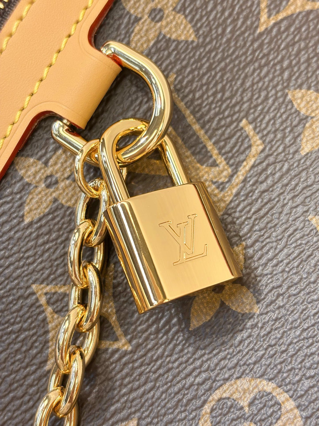 Louis Vuitton monogram bag charm lock with gold-tone padlock on leather trim