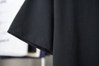 Black T-shirt sleeve and hem detail with clean stitched edges