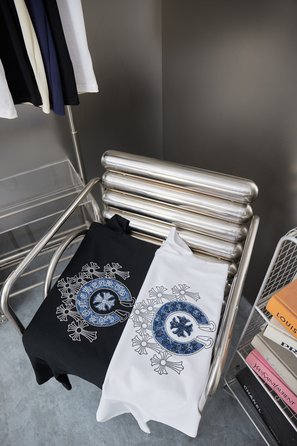 Folded black and white T-shirts with blue circular emblem on front