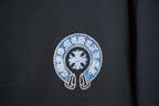 Black T-shirt front close-up of blue crystal emblem with white border