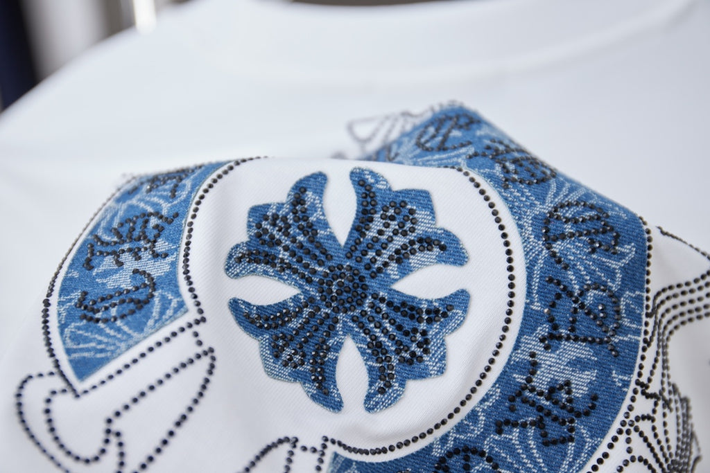 Embroidered blue circular emblem on white T-shirt, close-up