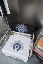 Folded black and white short-sleeve T-shirts with blue circular emblem