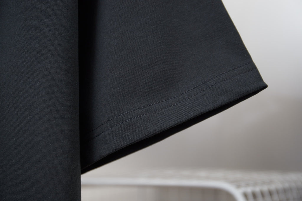 Black T-shirt sleeve and hem with visible stitching