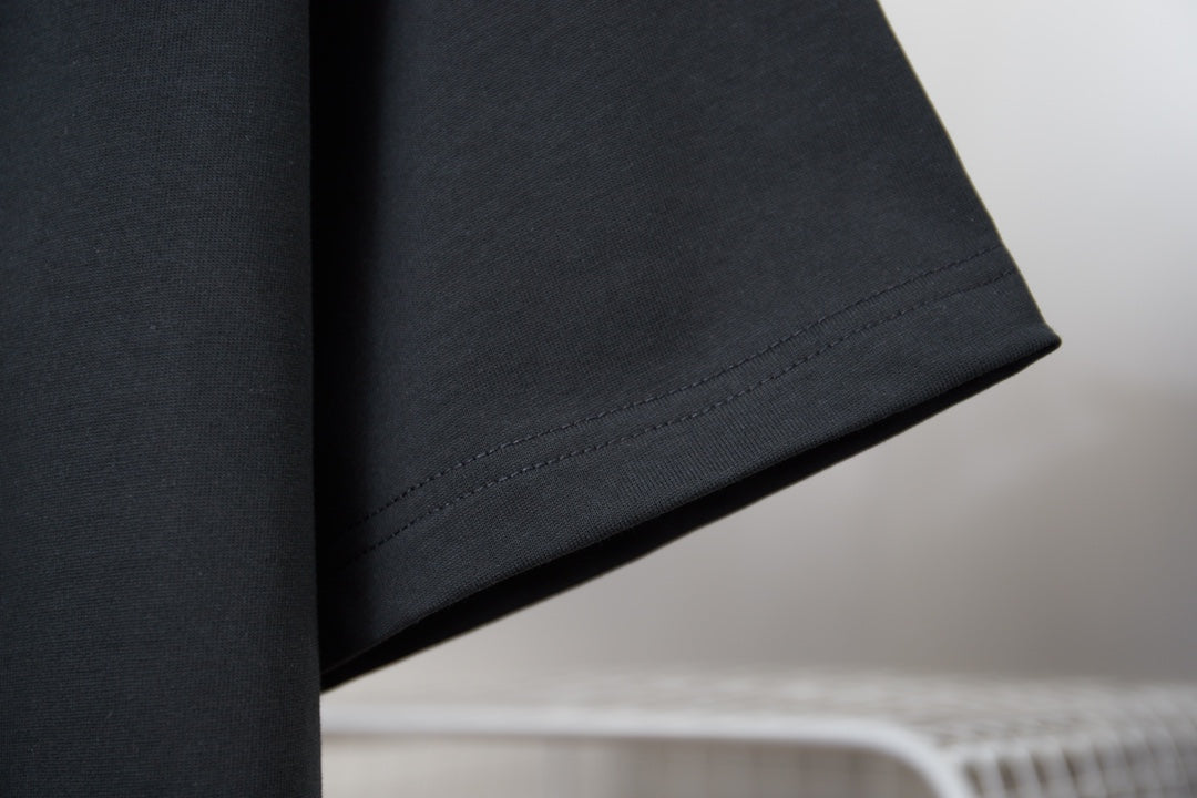 Black T-shirt sleeve and hem with visible stitching