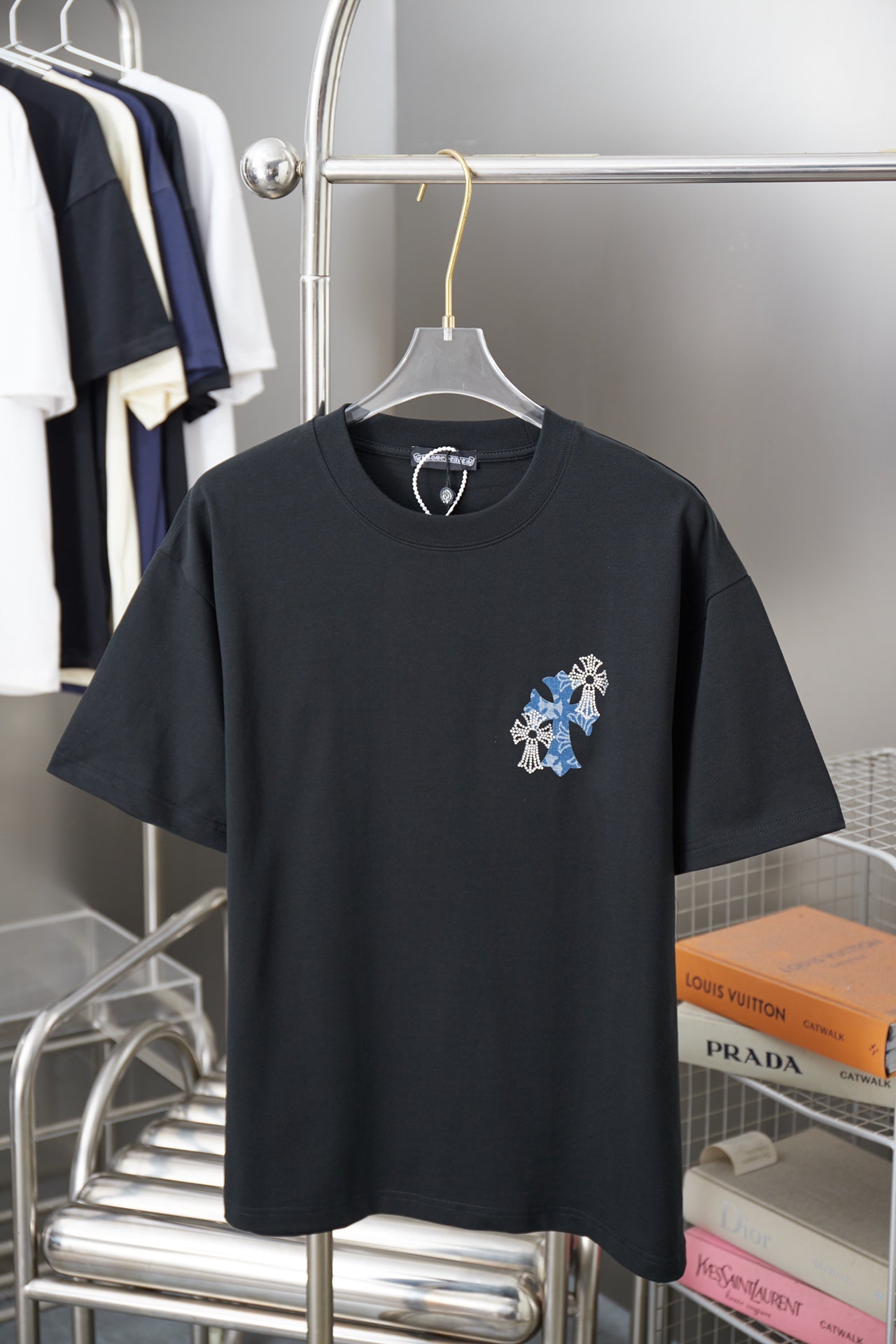 Black graphic T-shirt with blue flower cross patch on left chest