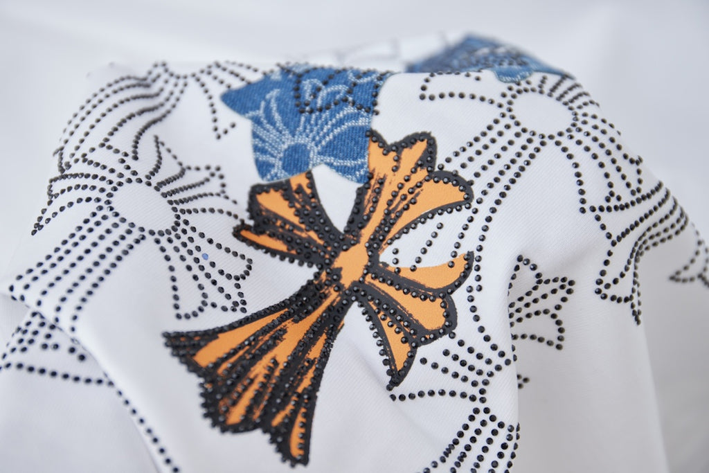Orange, blue, and black floral cross embroidery on a white T-shirt