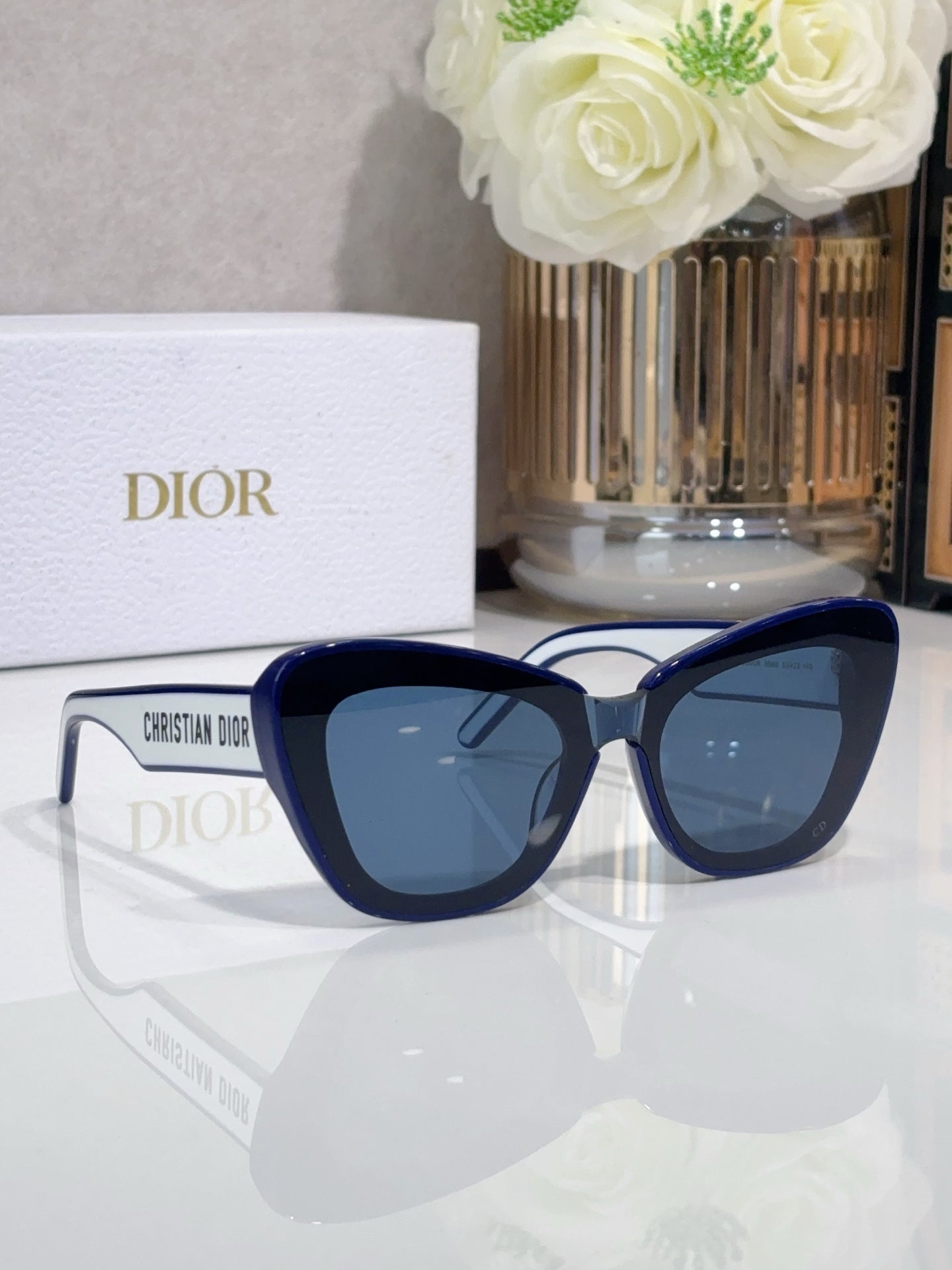 Dior sunglasses with navy cat-eye frames and dark lenses, side view