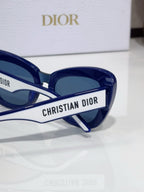 Dior sunglasses close-up with 'Christian Dior' logo on blue temple
