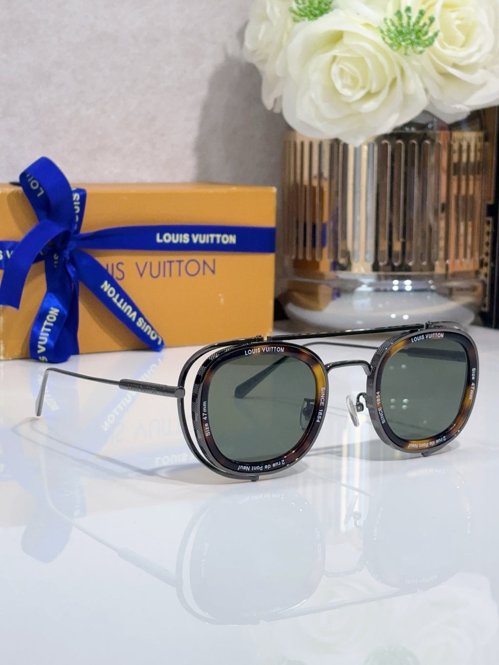 Louis Vuitton round sunglasses with tortoise-tone frame and dark green lenses, front view.