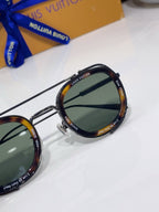Louis Vuitton round sunglasses close-up with tortoise-tone frame and dark lenses.
