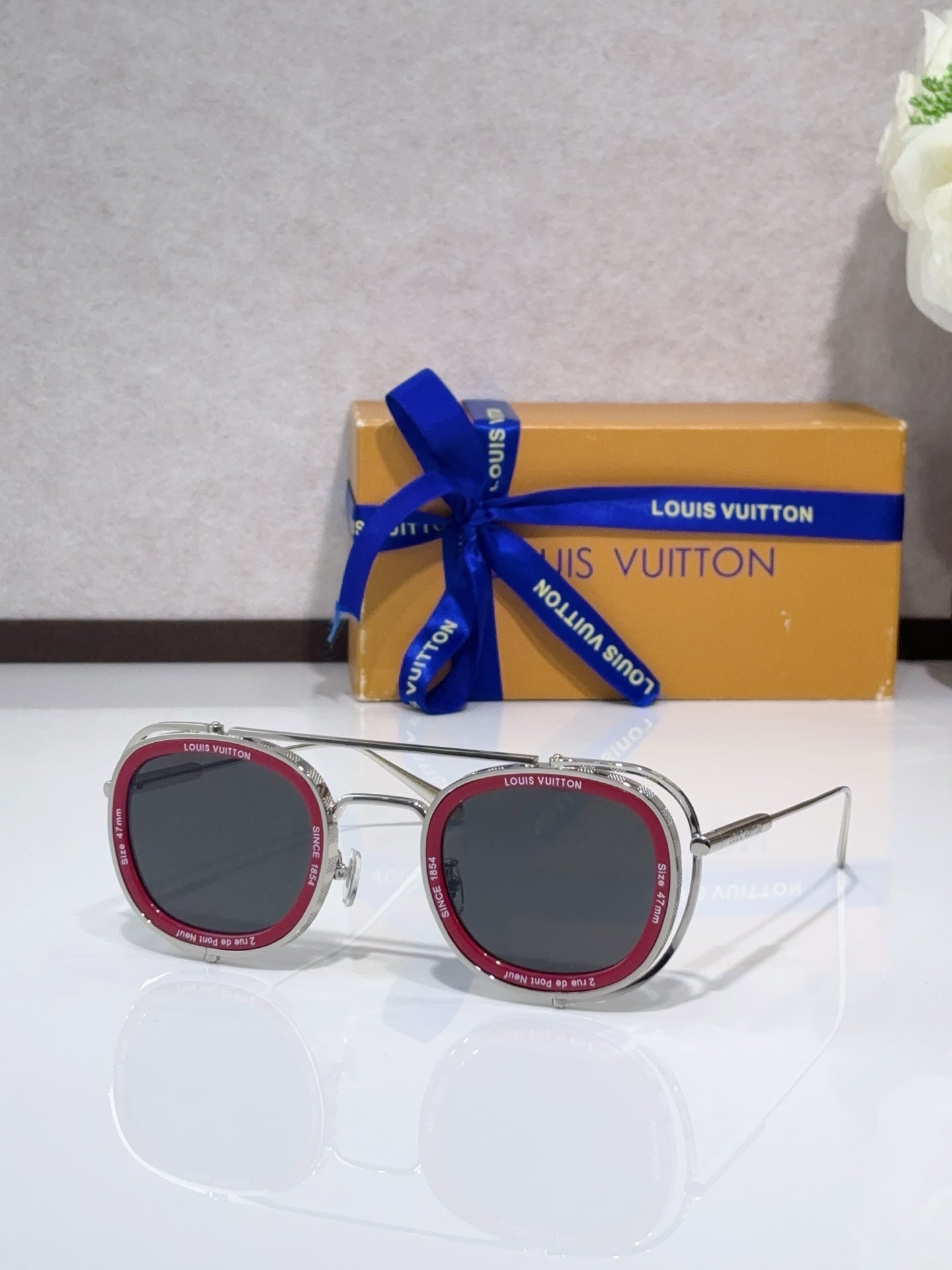 Louis Vuitton round sunglasses with pink-trim frame and dark lenses, open temples.