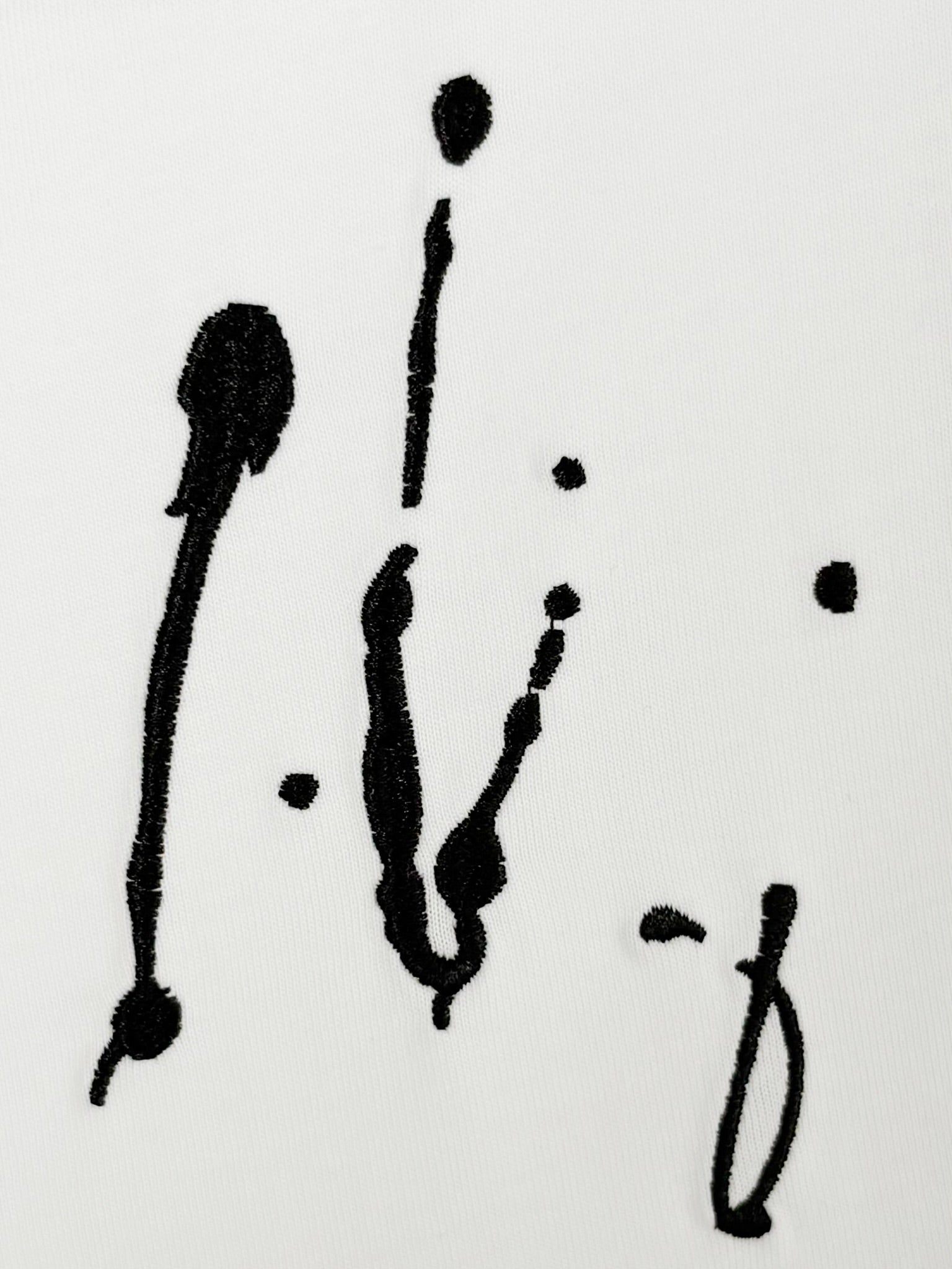 White Louis Vuitton T-shirt close-up of black scribble-style artwork print