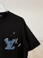 Black T-shirt sleeve with blue and white embroidered graphic logo