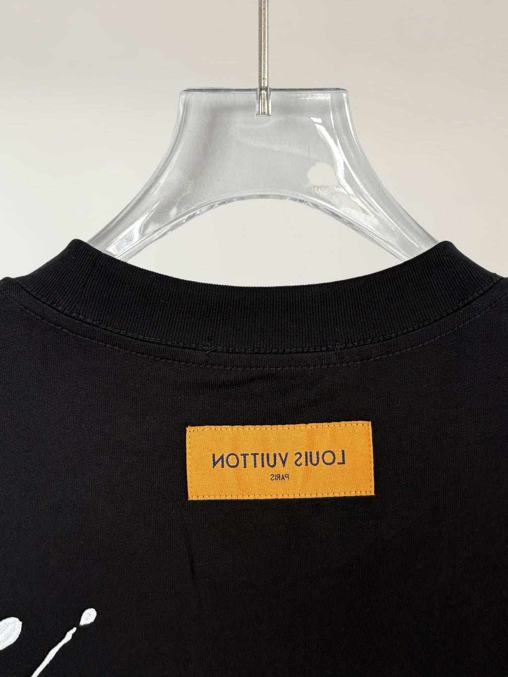 Black T-shirt back neckline with yellow logo label at center