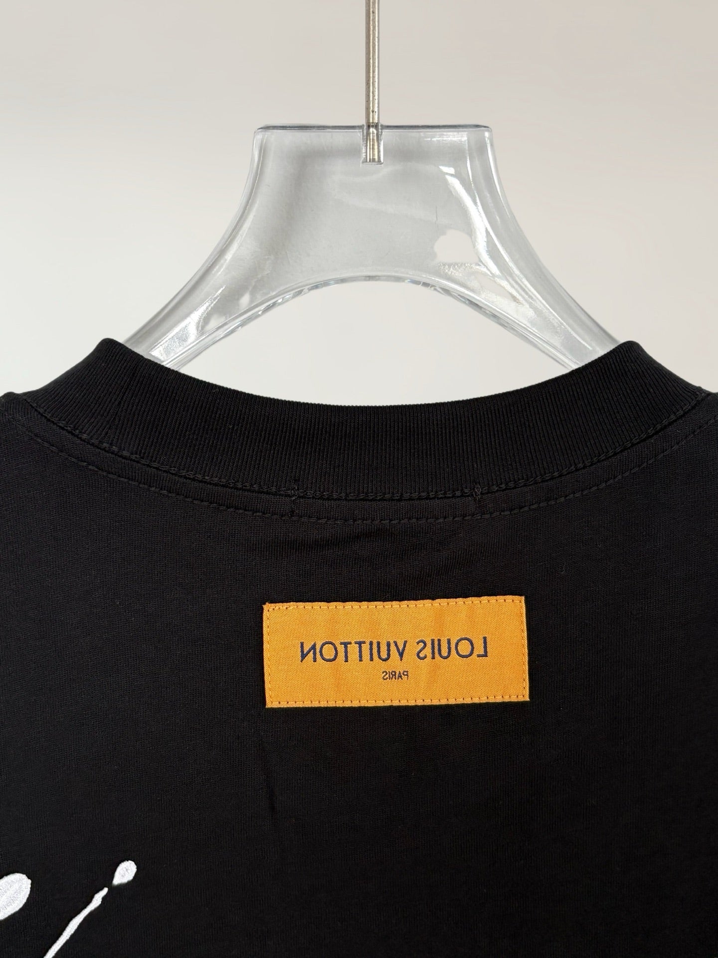 Black T-shirt back neckline with yellow logo label at center