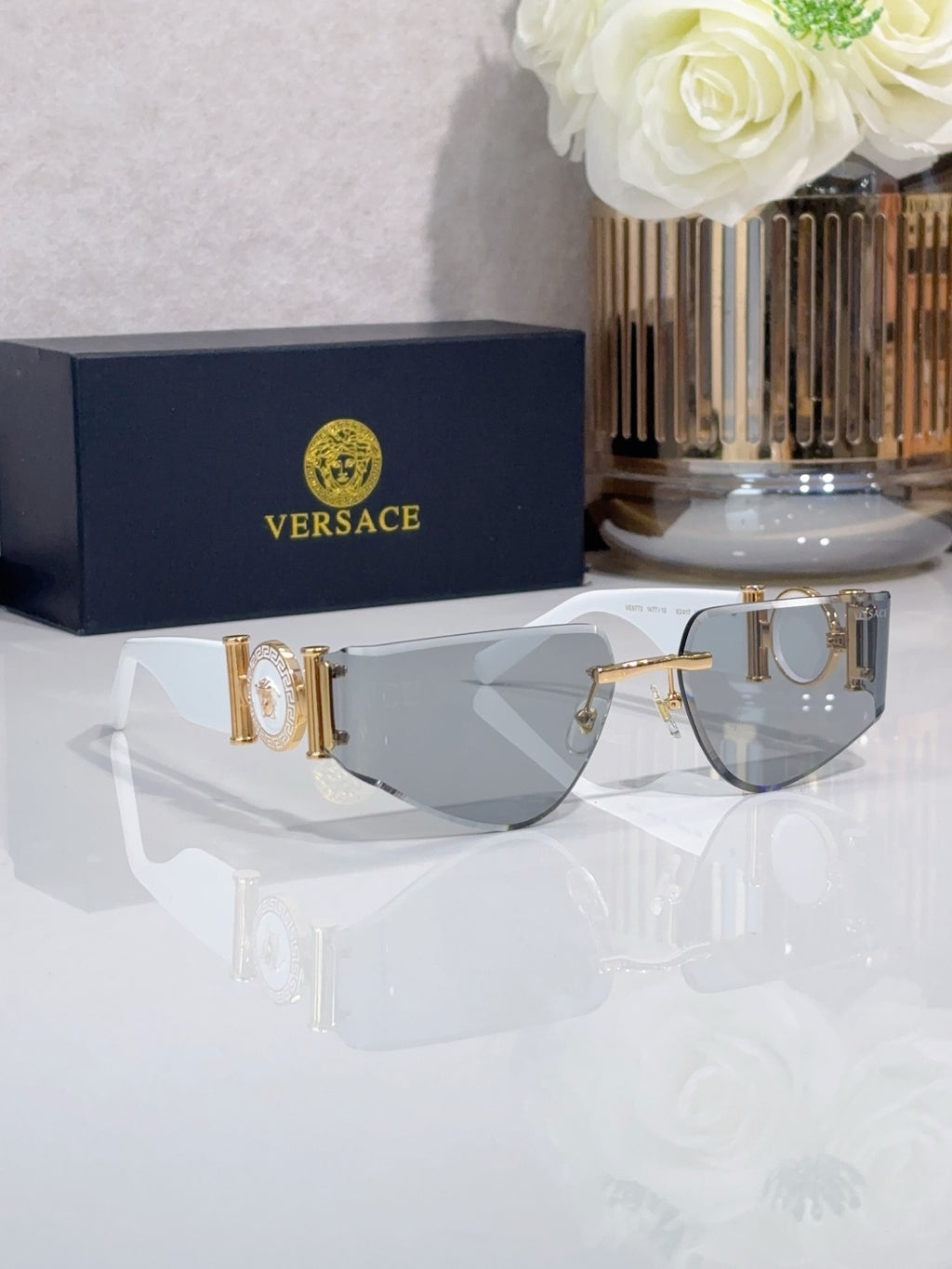 Shield sunglasses with gold-tone metal frame and gray tinted lenses