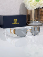Shield sunglasses with gold-tone metal frame and gray tinted lenses