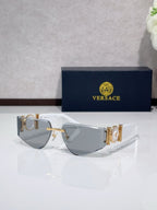 Shield sunglasses with pale frame, gold-tone accents, and gray tinted lenses