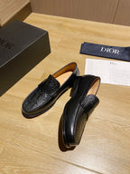 Black leather loafers with embossed panels and low stacked heel sole