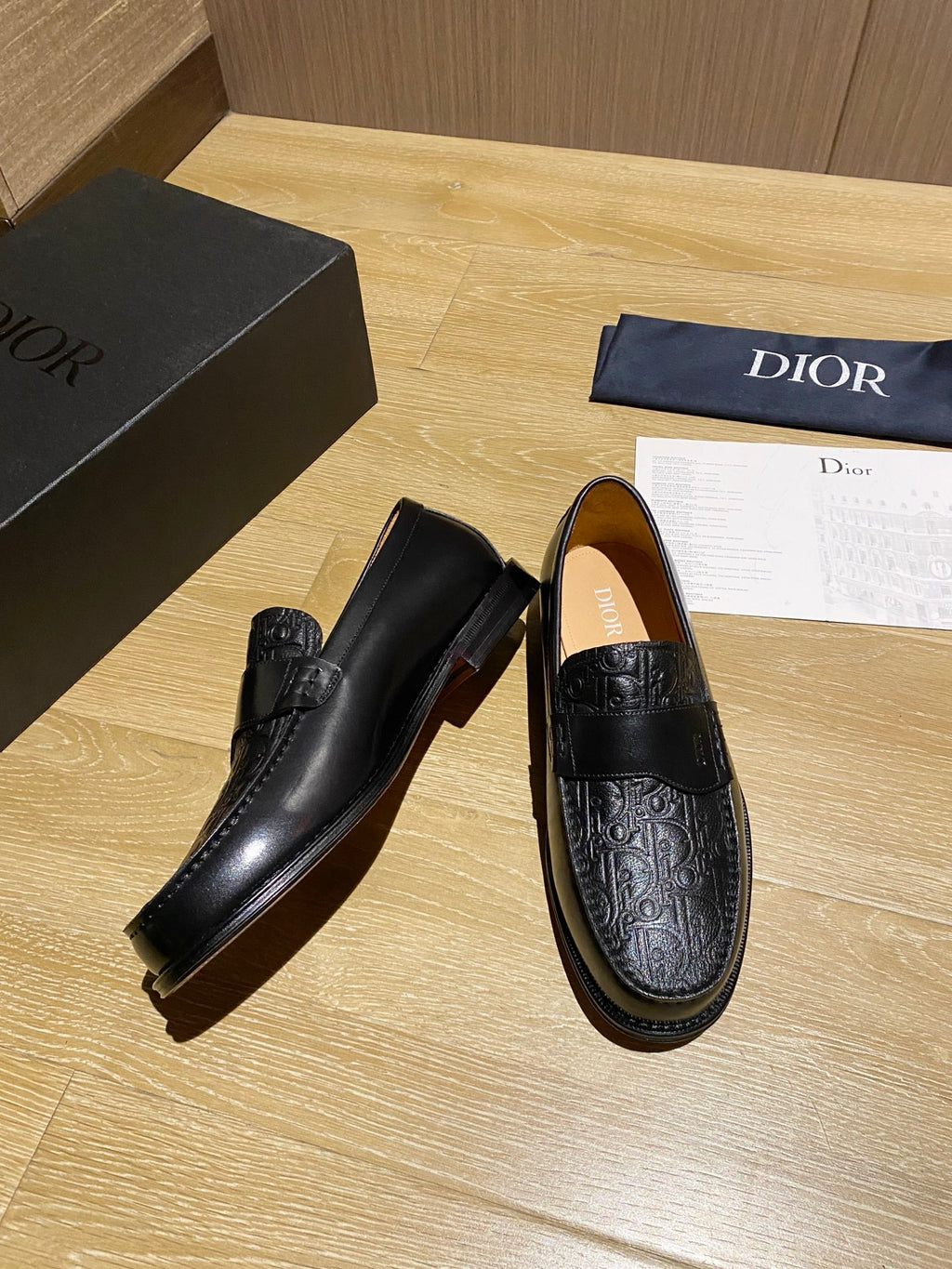 Black leather slip-on loafer with embossed toe and side strap detail