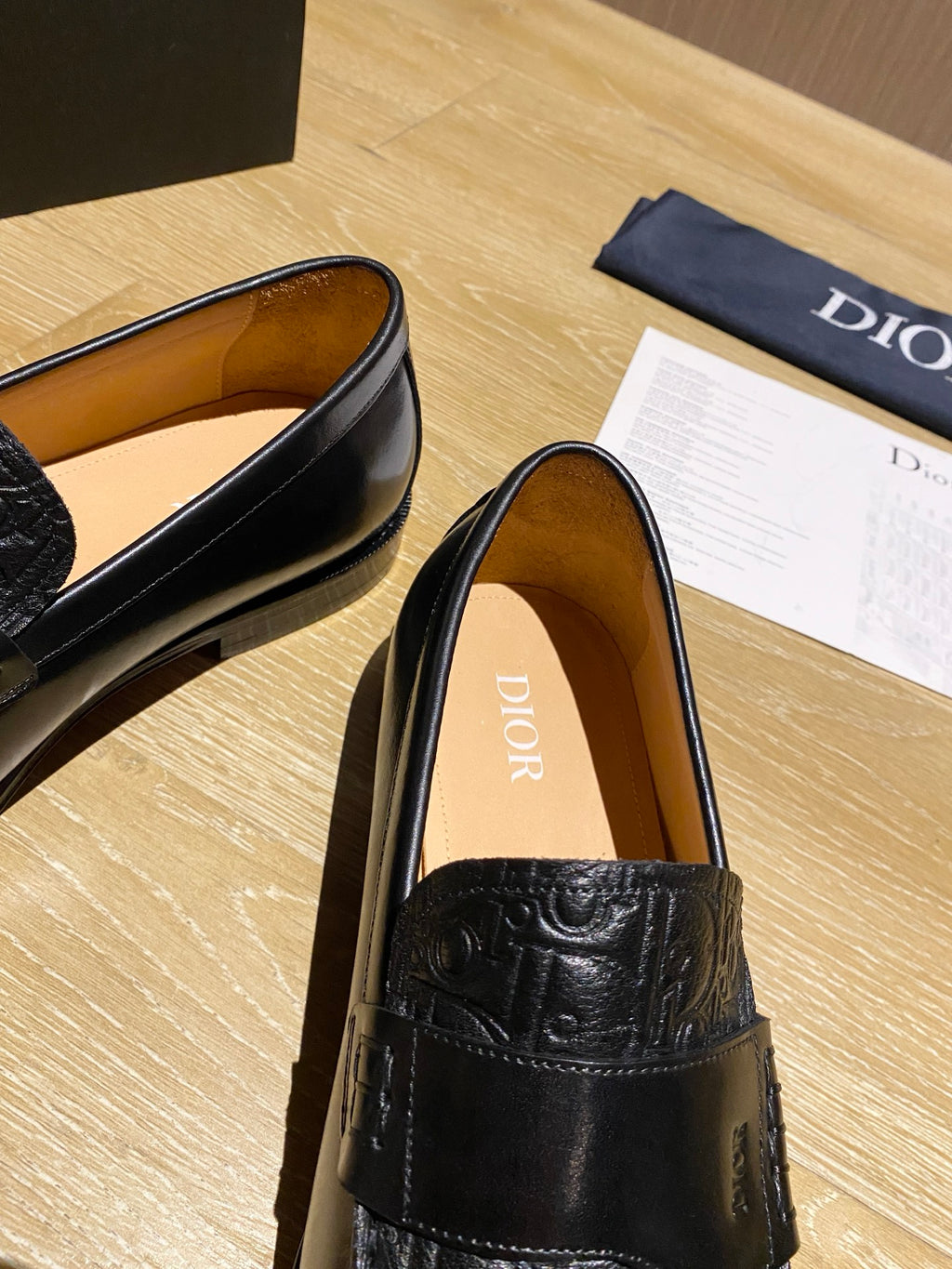 Black leather loafer with embossed front and tan interior lining