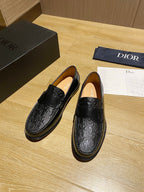 Pair of black leather loafers with embossed trim and slip-on vamp