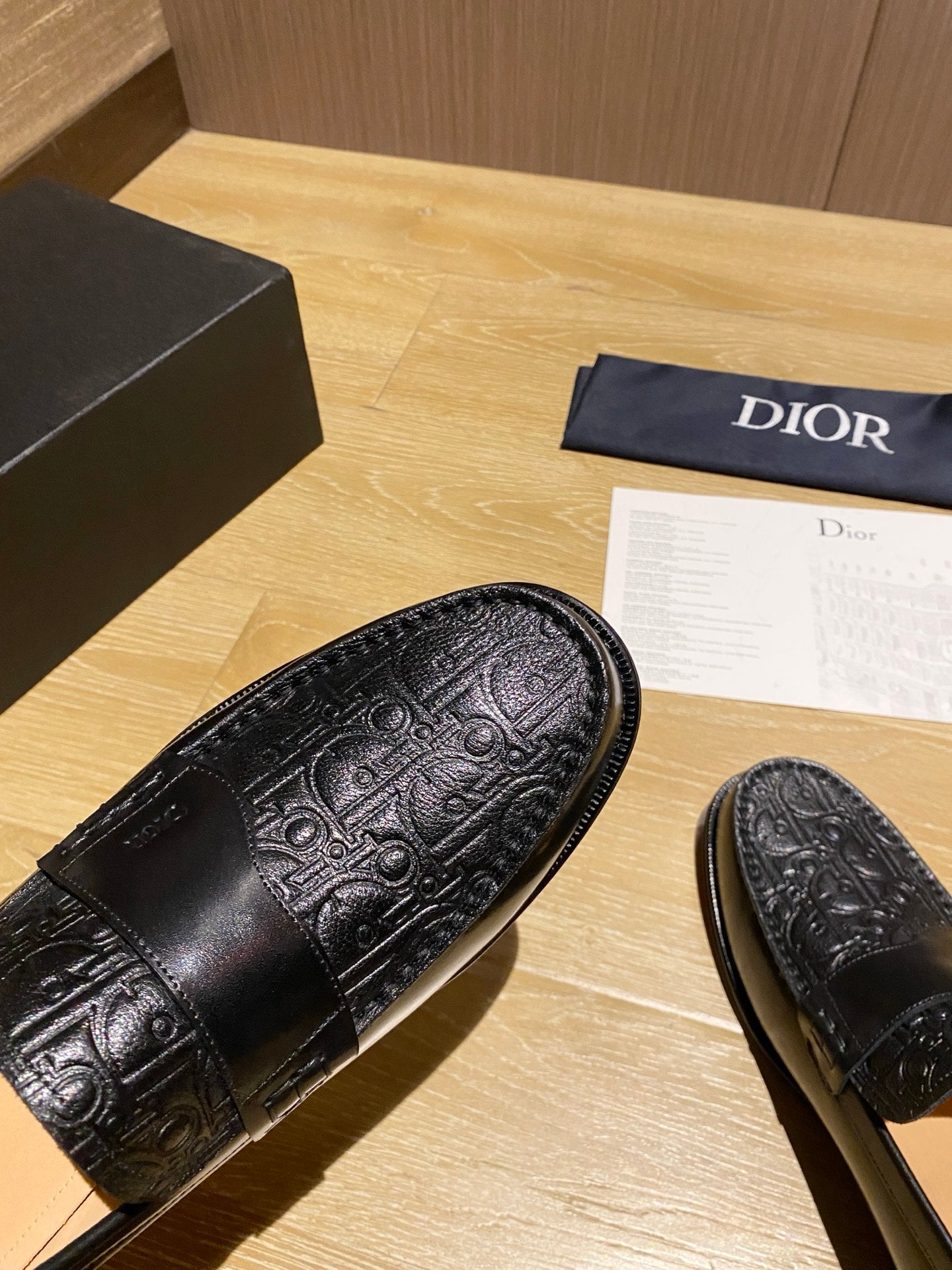 Close-up of black embossed leather loafer vamp with decorative stitching