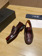 Pair of burgundy leather loafers with embossed uppers and rounded toe