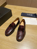 Dark red leather loafers with glossy finish, strap detail, and stitched edges