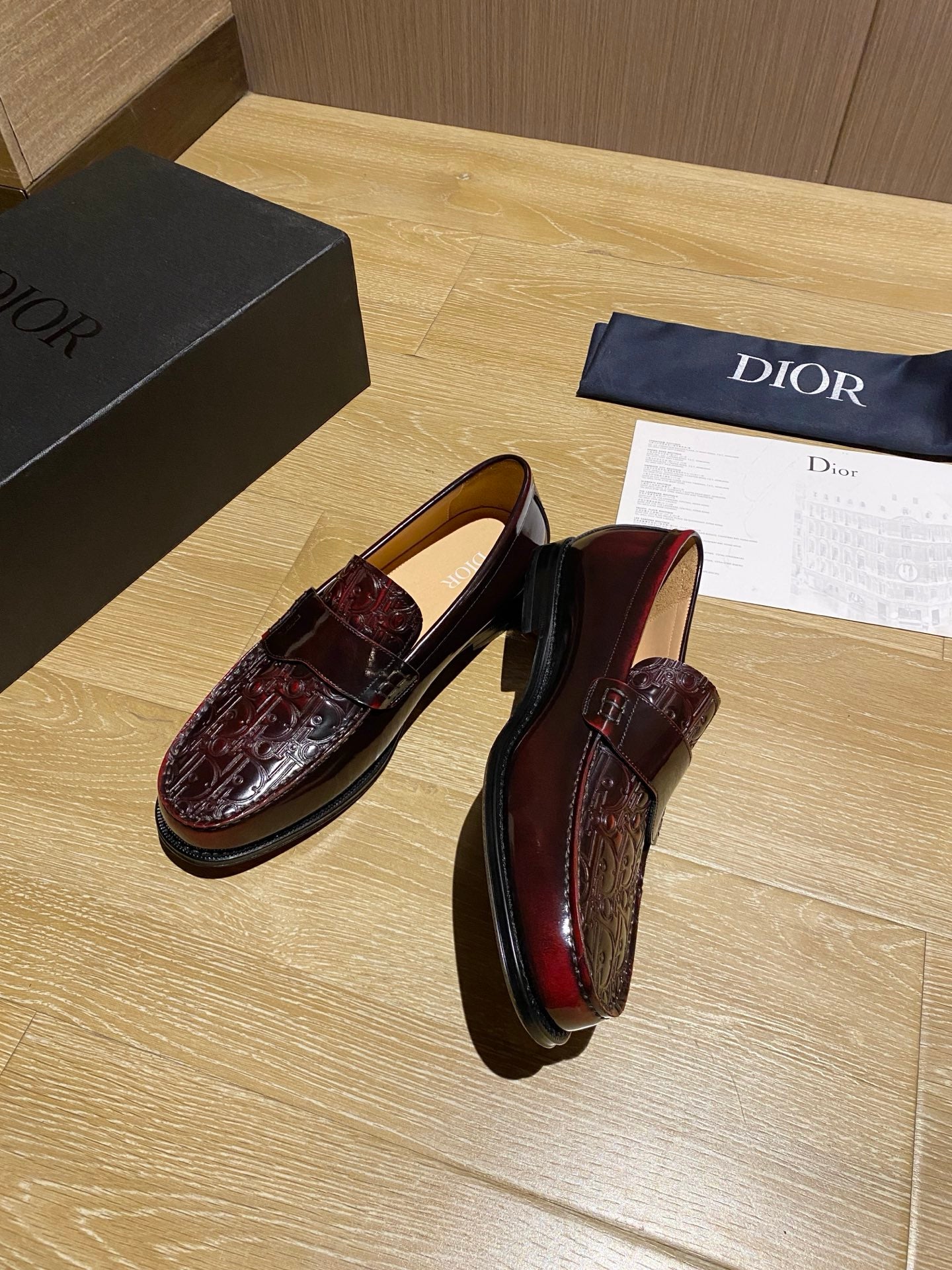 Burgundy leather slip-on loafers with strap detail and embossed vamp