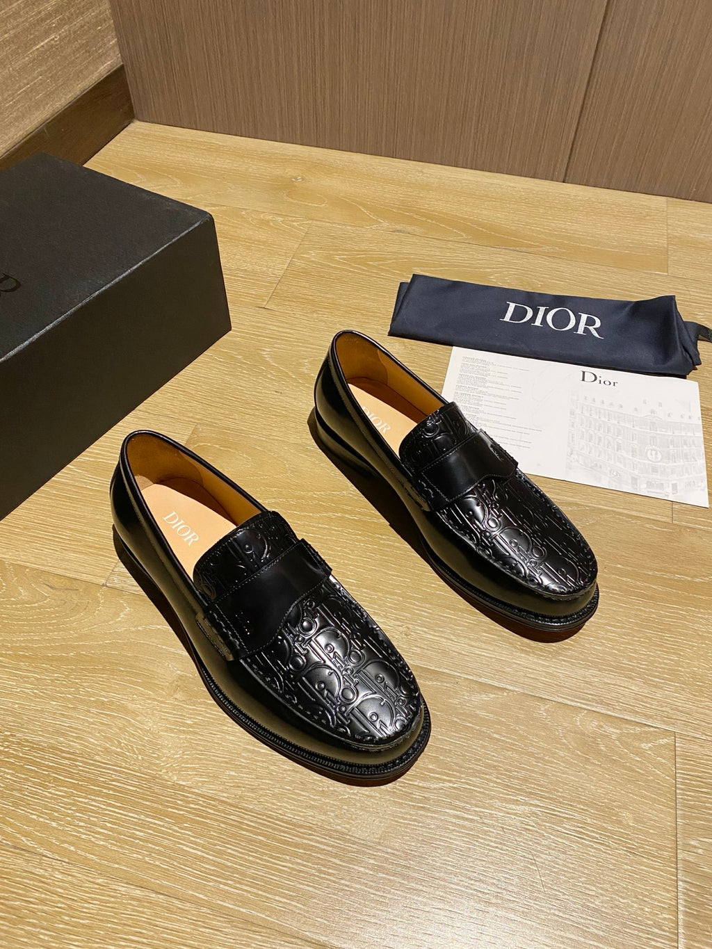 Black leather loafers with glossy embossed pattern and moc-toe stitching