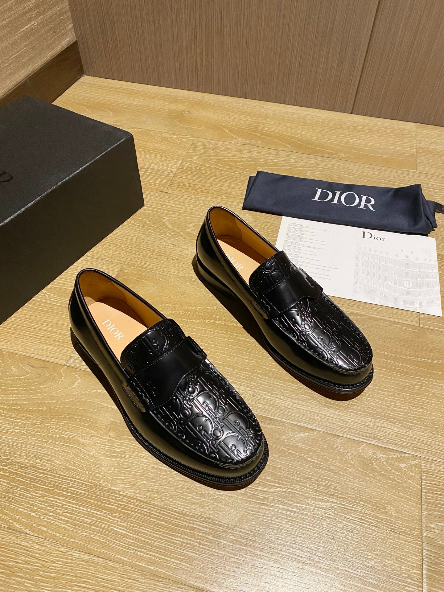 Black leather loafers with glossy embossed pattern and moc-toe stitching