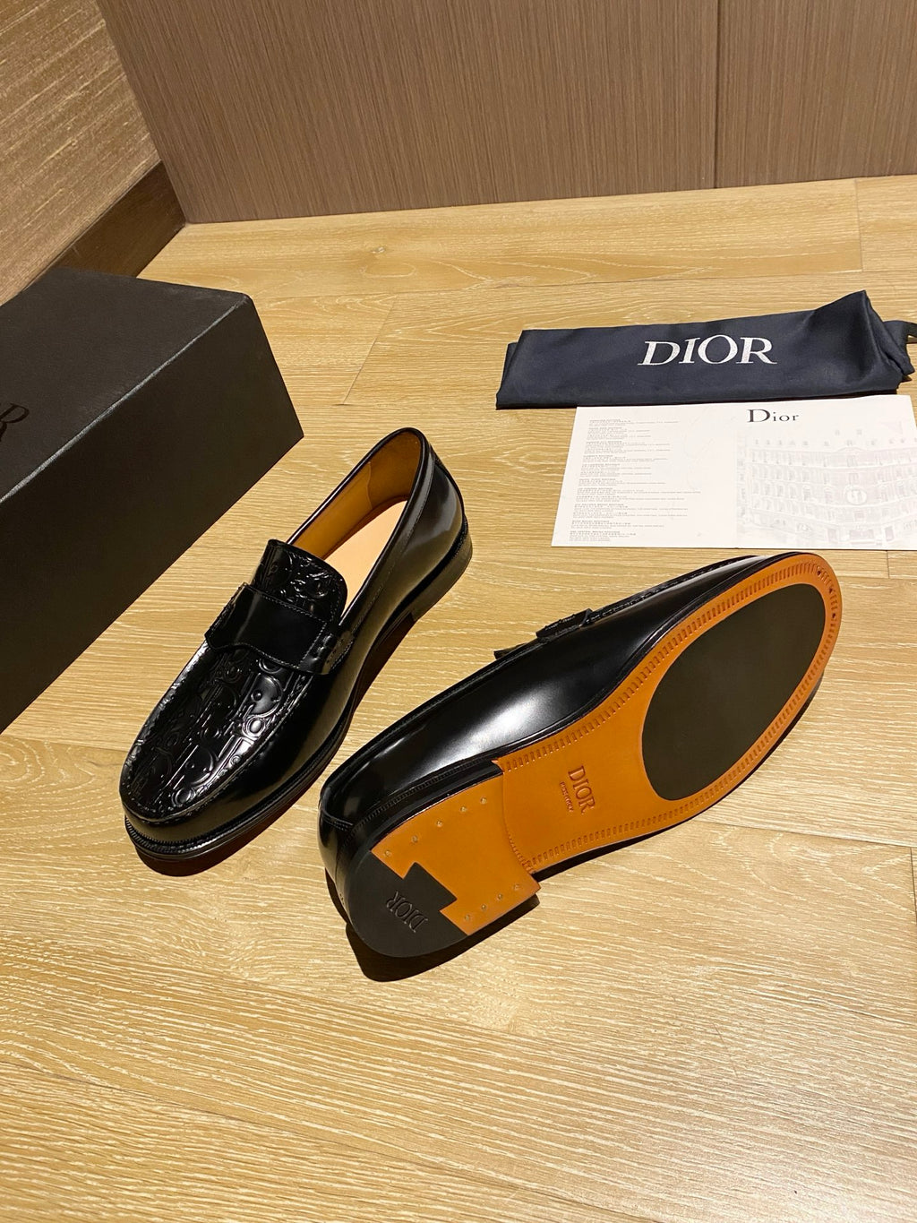 Black leather loafer with tan insole and orange outsole interior