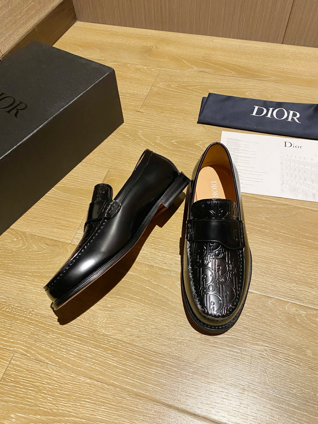 Black leather loafers, side view, with embossed decorative detailing