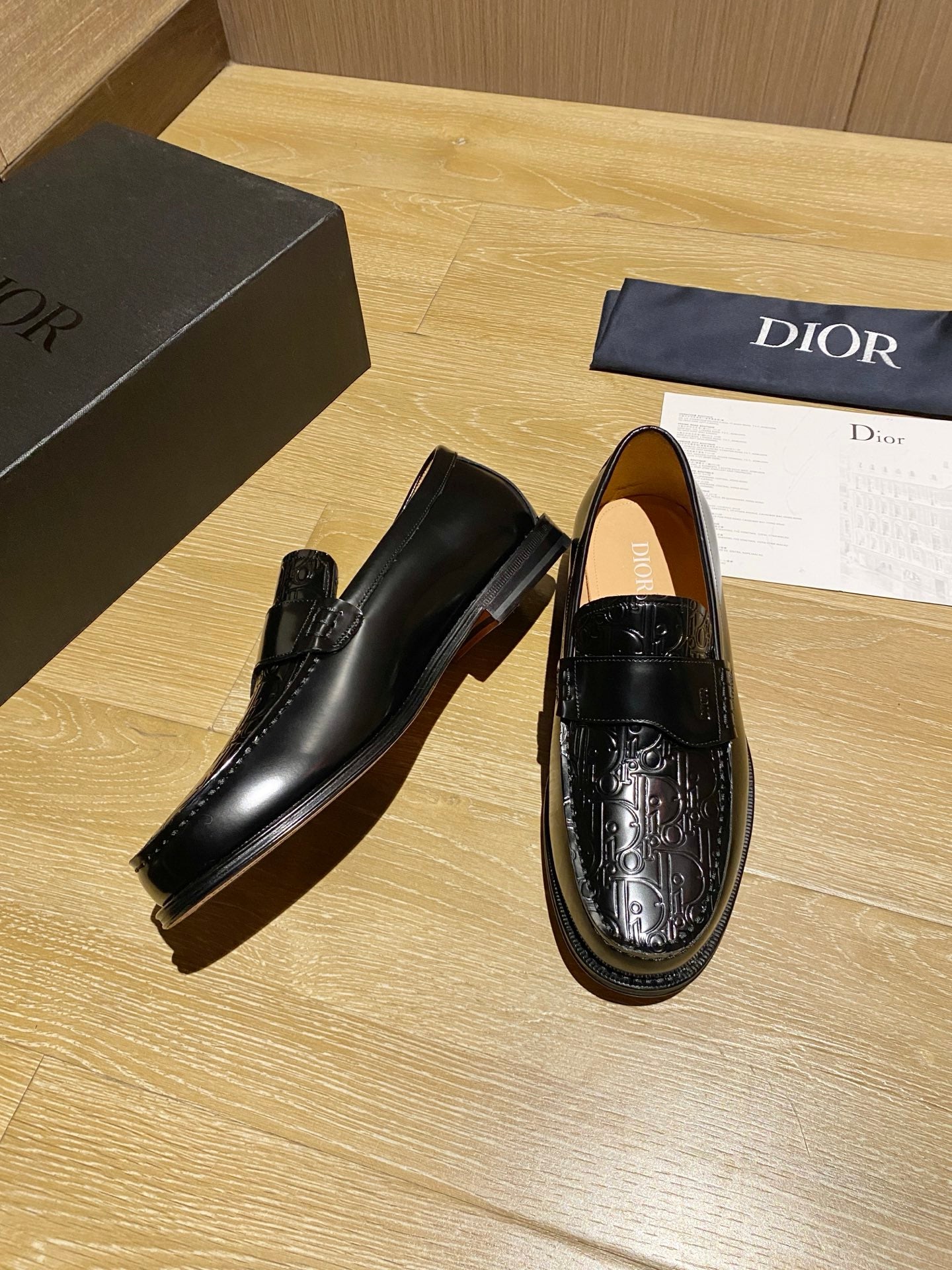 Black leather loafers, side view, with embossed decorative detailing
