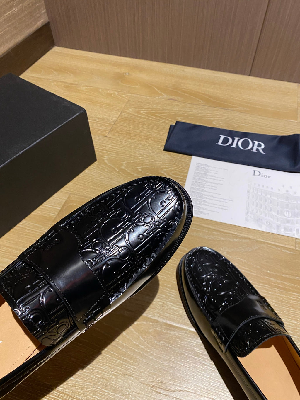 Close-up of black leather loafer upper with ornate embossed swirl pattern
