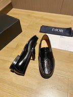Black leather loafers side profile, glossy embossed moc-toe