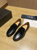 Black leather loafers pair, front view, with glossy embossed texture