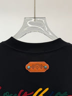Black short-sleeve shirt neckline with orange logo patch detail