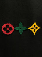 Black knit fabric with red, green, and yellow emblem patches