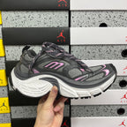 Unisex running sneakers on box, dark gray upper with pink accents and white sole
