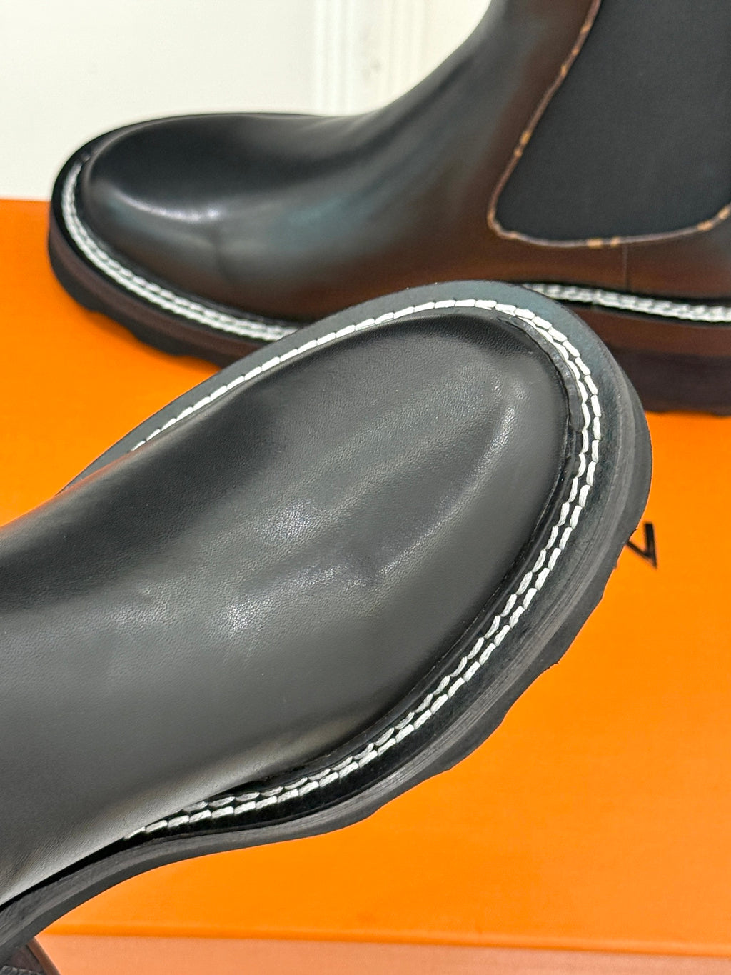 Louis Vuitton black leather chelsea boot close-up, contrast stitched edge, chunky tread