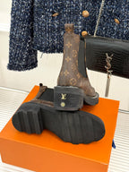 Louis Vuitton monogram chelsea boots showing outsole tread on orange box