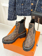 Louis Vuitton monogram chelsea boots with black elastic gore, side view on orange box