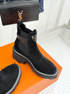 Black suede ankle boots with dark logo patch and contrast-stitched sole edge