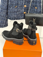 Black suede ankle boots with buckled strap and chunky rubber soles