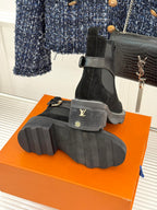 Black suede ankle boots showing outsole tread and heel logo detail