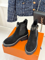 Pair of black suede ankle boots with elastic panels and chunky tread soles