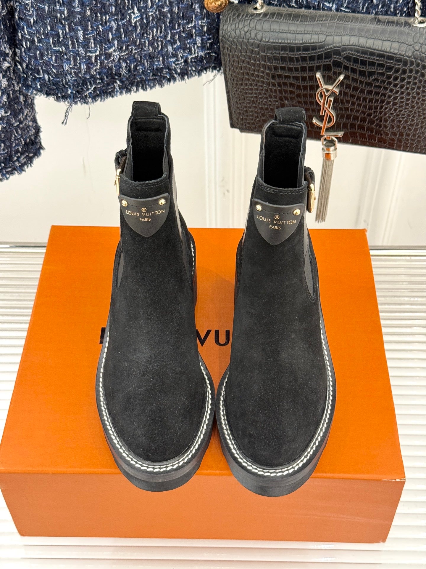Black suede Chelsea boots with pull tabs and contrast-stitched edges