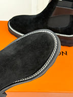 Black suede ankle boot toe with contrast-stitched side trim